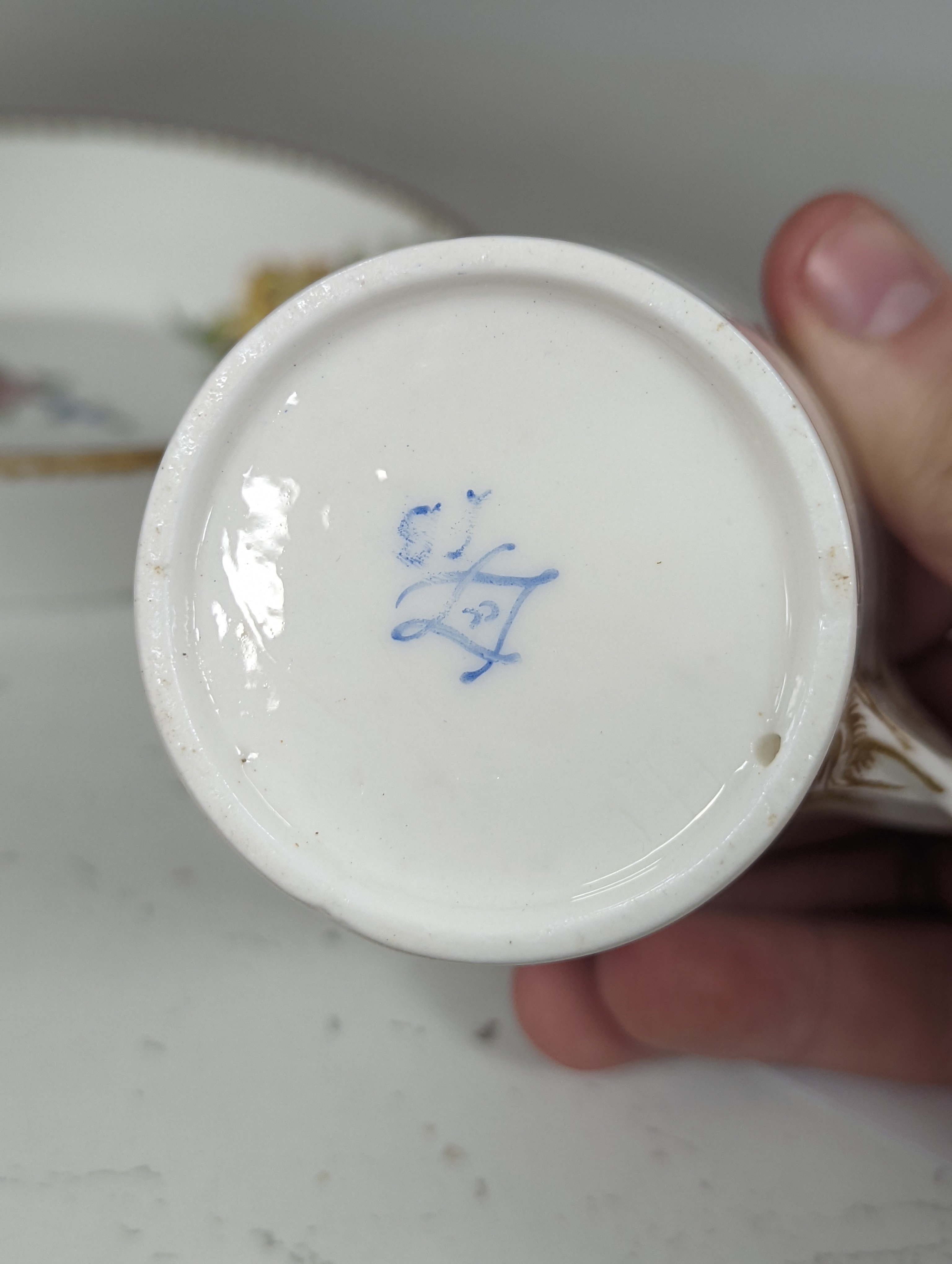 A Sevres tapering cup with entwined handle and cover and stand painted with flowers, date code for 1780, painters mark for Le Bel jnr., square incised marks, height 10.5cm